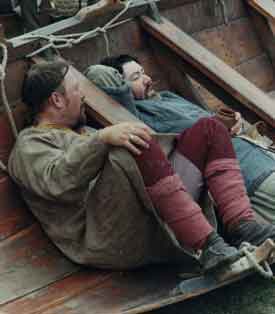 * Two men resting in a boat pulled up onto land